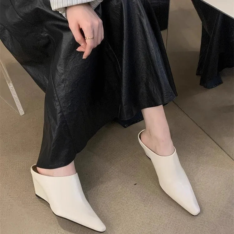 Women's black wind wedge closed toe half slippers showing PU upper and open back.