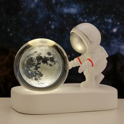 Glowing astronaut crystal ball night light with 6cm diameter and USB cable on wooden surface