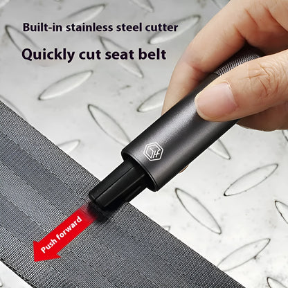 Gun grey aluminium car safety hammer with seatbelt cutter on a 3M rubber base next to a test glass.