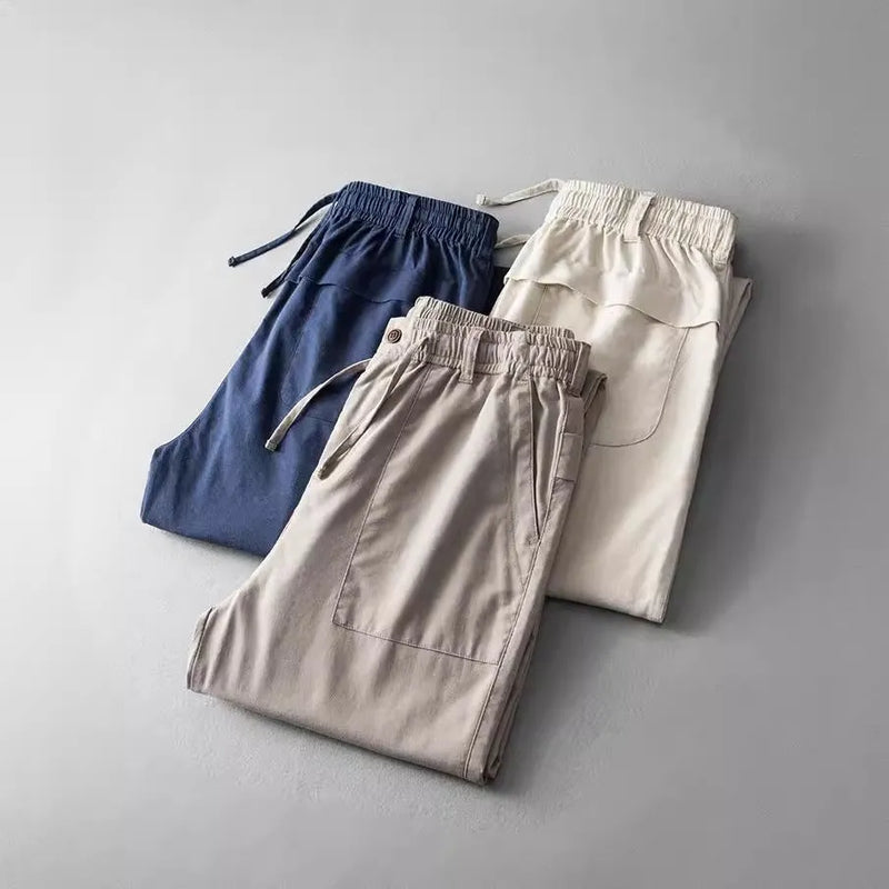 Men's trousers in solid colour linen fabric with inelastic mid-waist design suitable for leisure wear available in Navy Blue, Apricot Linen, and Grey in sizes from M to XXXL