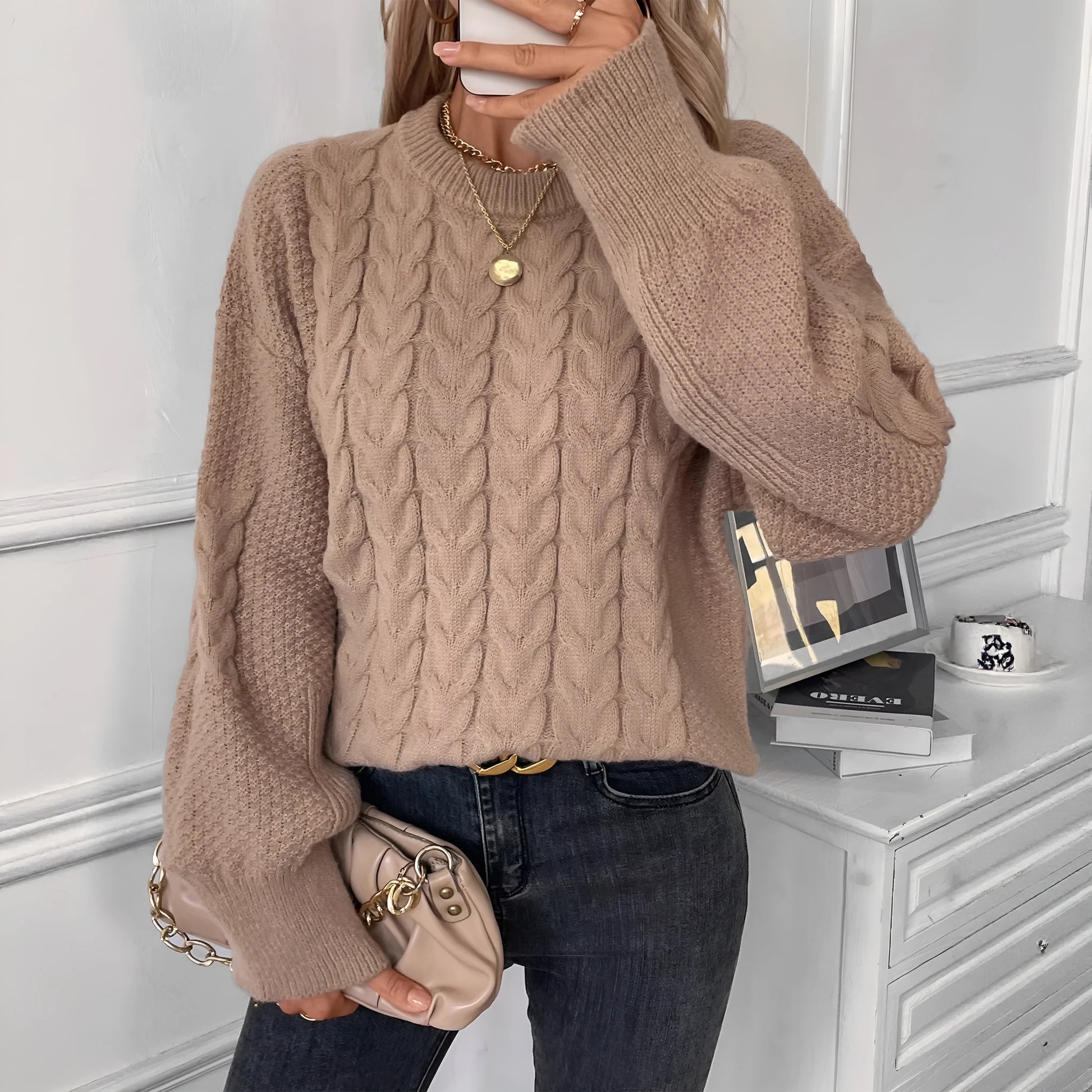 Women's beige twist knit loose sweater with round neck and regular sleeves on a hanger