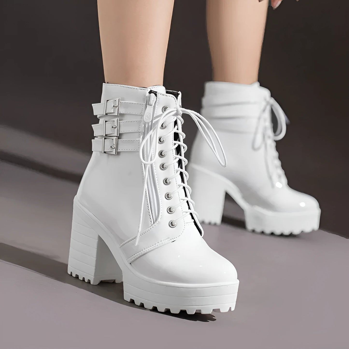 Women's black chunky heel ankle boots with round toe and front lace-up on a wooden floor.