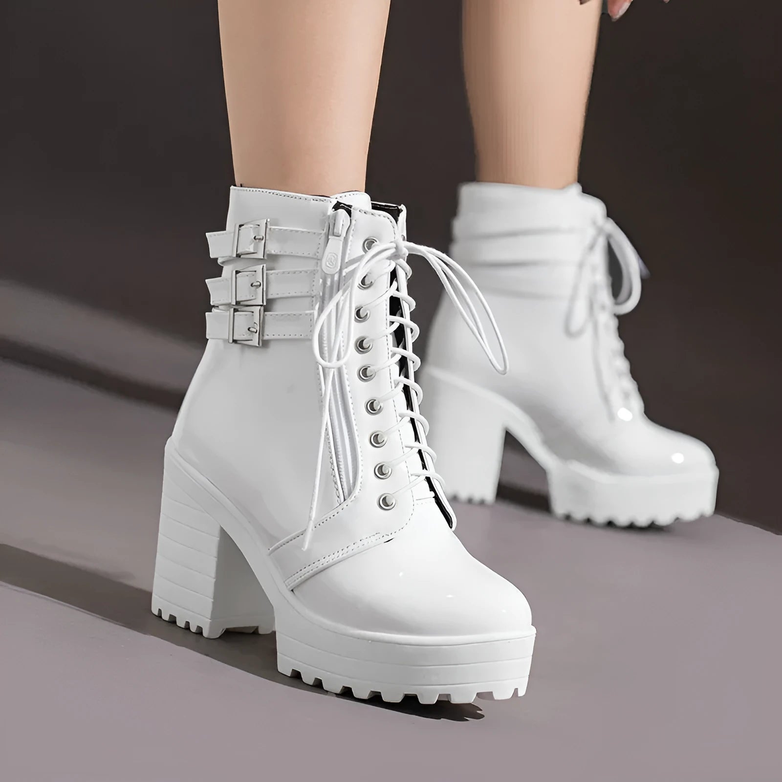 Women's black chunky heel ankle boots with round toe and front lace-up on a wooden floor.