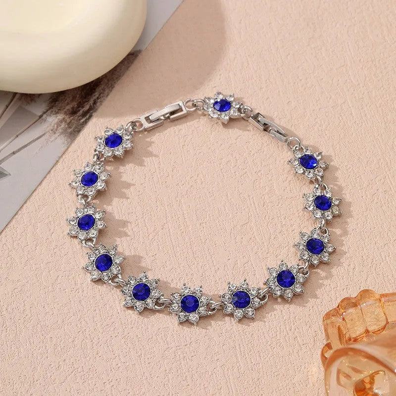 Gold and silver electroplated bracelets with flower charms set with coloured gemstones.