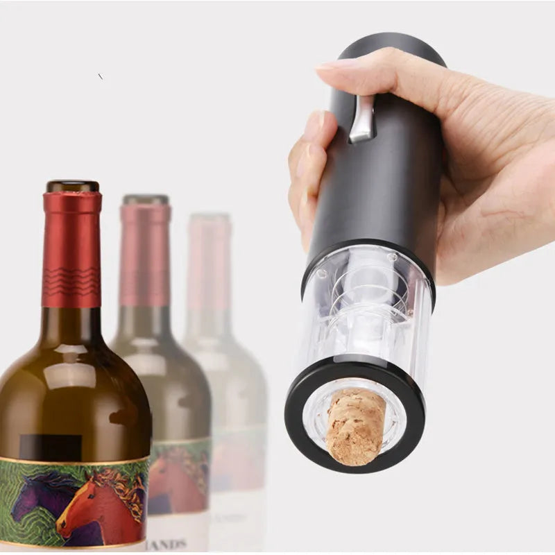 Black electric wine opener with transparent cover and aluminum foil cutter on wooden table