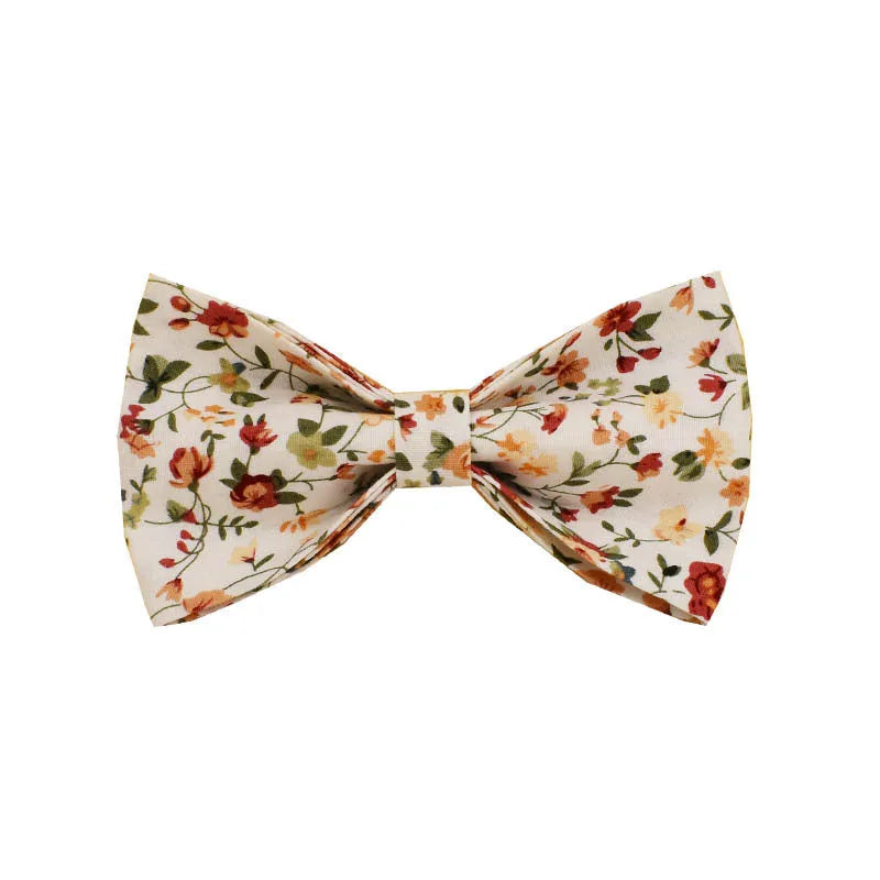 Small white flower decoration on a cloth dog collar and leash set with matching vest and bow.