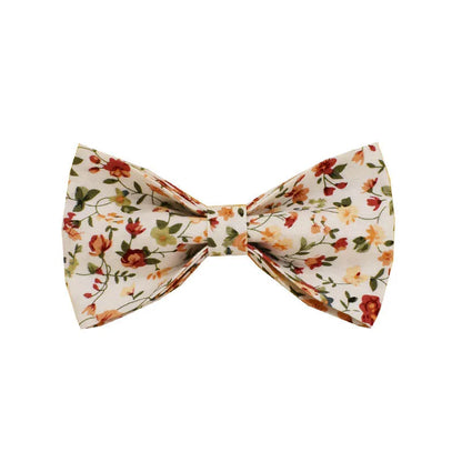 Small white flower decoration on a cloth dog collar and leash set with matching vest and bow.
