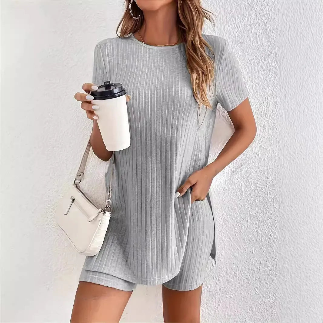 Woman wearing a grey ribbed cotton crew neck top and matching shorts from a two-piece suit set.