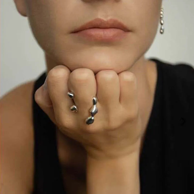 A minimalist brass ring with a small spherical detail on a plain band, shown in gold tone.