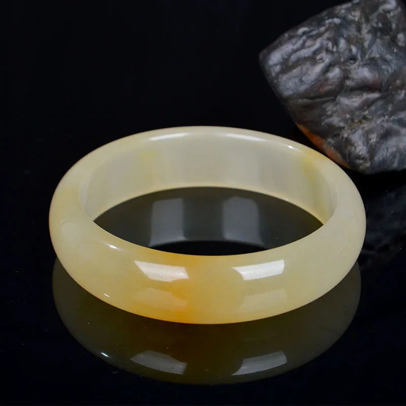 A polished natural jade bracelet in a traditional Chinese style, shown with a size guide for 54mm to 62mm.