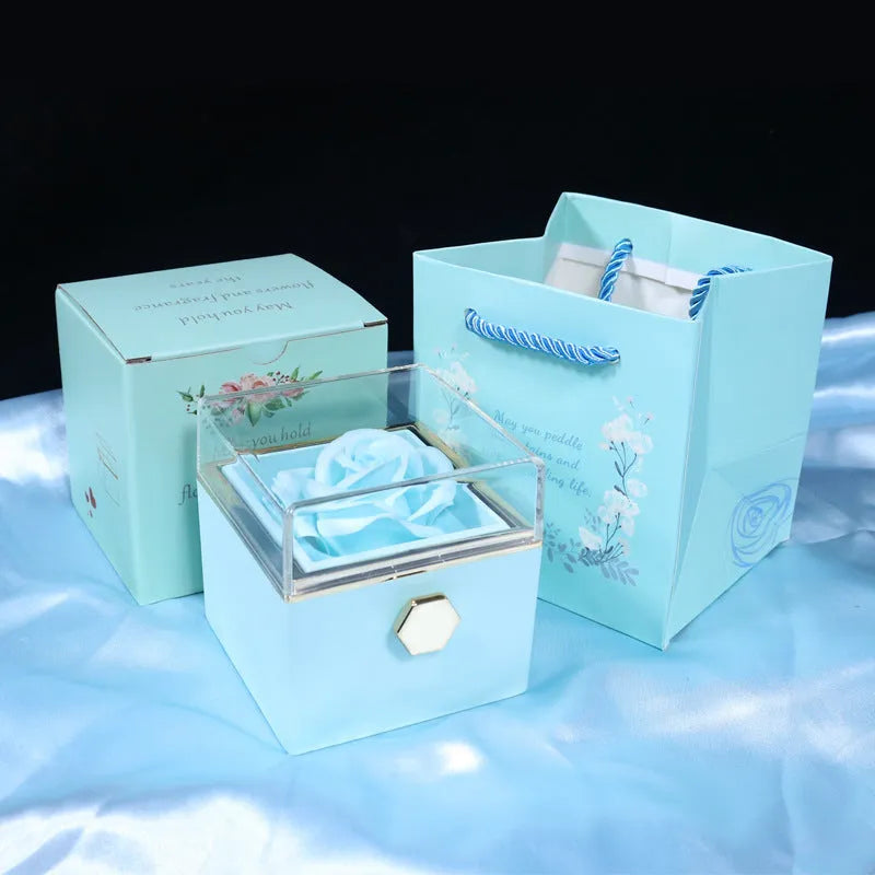 Rotating rose jewellery gift box with a preserved red rose under a clear acrylic dome, showing the interior rotating drawer.