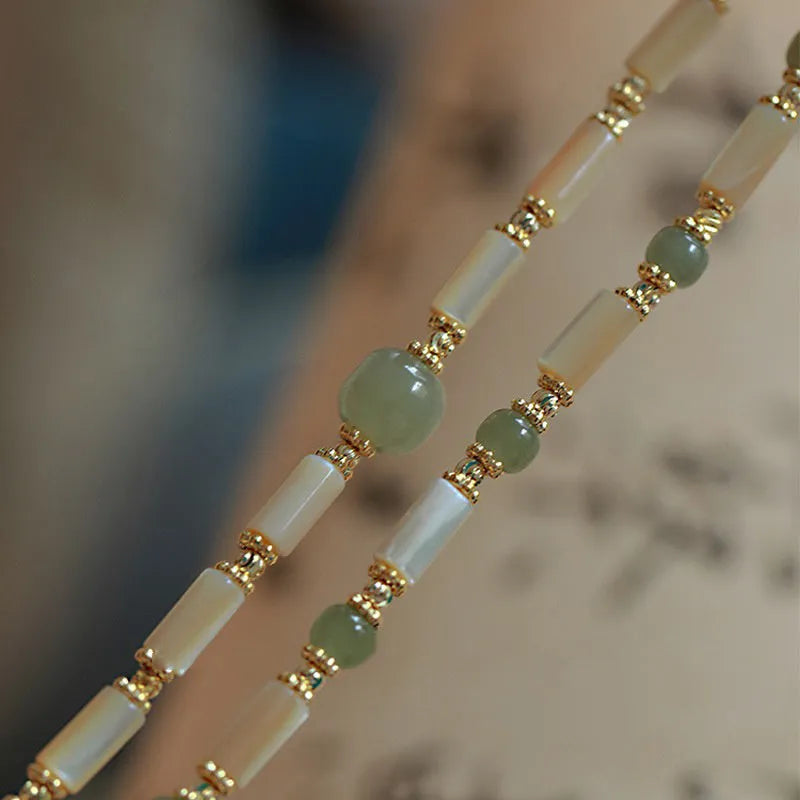 Hetian Jade white lip shell bracelet with geometric round beads on wrist