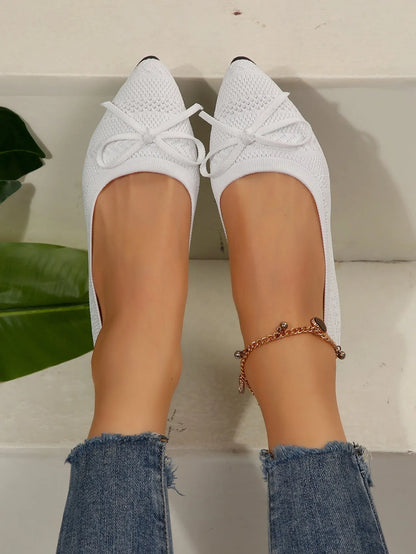 Women's blue knitted loafer flat shoes with a pointed toe and decorative bow detail on the front.