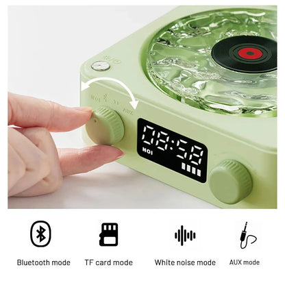 Retro-style turntable Bluetooth speaker with glowing RGB light projection on a wooden surface.