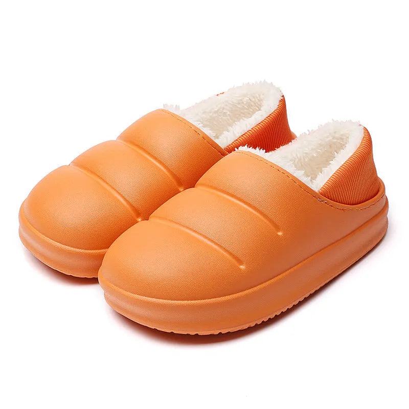 Pair of yellow waterproof EVA slippers with plush lining and a textured non-slip sole on a wooden floor.