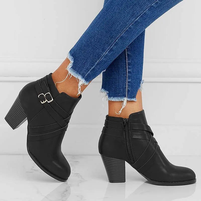 Women's short ankle boots with a belt buckle and side zip in black, brown, or grey with a 7cm heel.