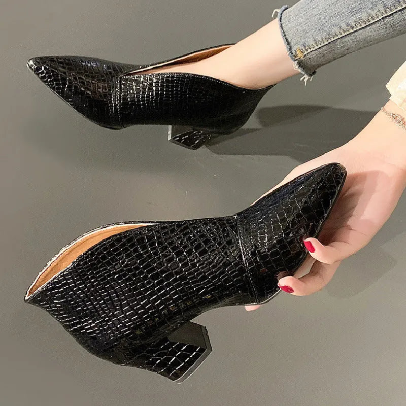 Women's black V cut Martin boots with a pointed embossed toe and a chunky heel.
