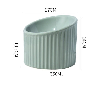 Ceramic elevated cat bowl in green colour showing tilted, round whisker-friendly design.