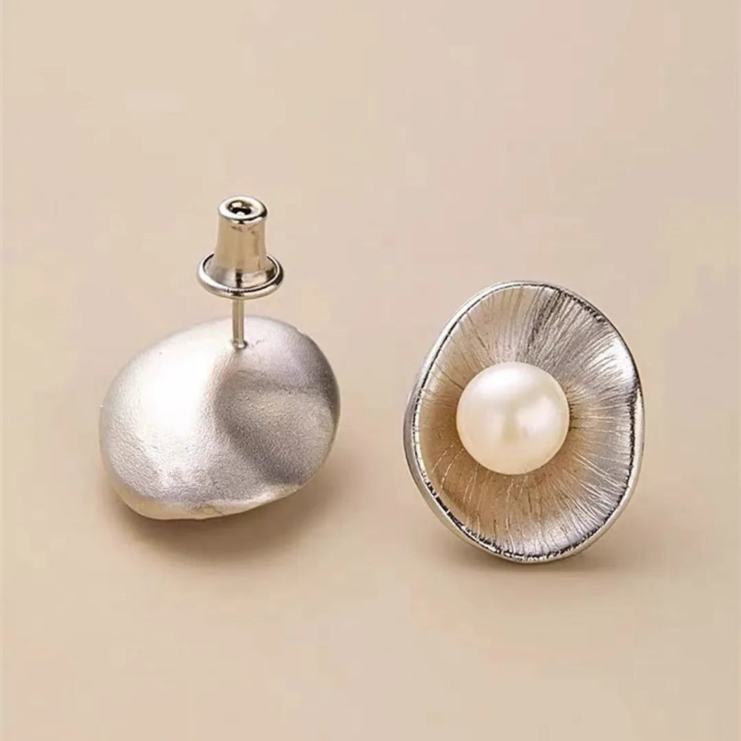 Silver geometric needle earrings with pearl decorative elements on female model