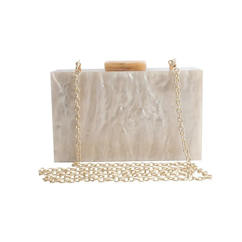 Small square acrylic clutch bag with long chain, marble pattern, and internal phone pocket