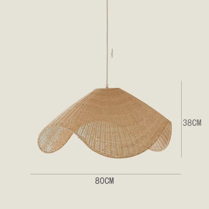 Handmade woven rattan and willow chandelier with warm LED light in a rustic setting.