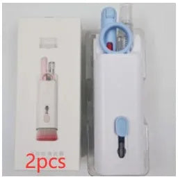 White electronics cleaning kit with a cleaning pen, spray bottle, brush, and keycap puller on a table