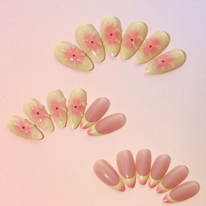 Set of simple fake nails with cartoon 3D flower design, jelly glue pot, and a nail file on a table.