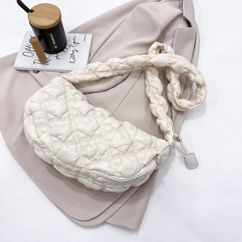 Women's light grey nylon underarm messenger bag with adjustable long strap, shown worn crossbody.