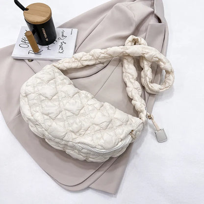 Women's light grey nylon underarm messenger bag with adjustable long strap, shown worn crossbody.