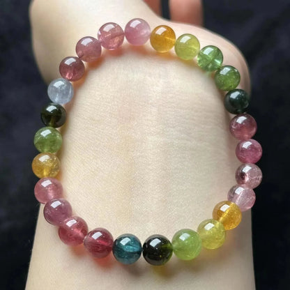 Colourful mixed-material women's bracelet with a four-leaf clover charm and a pearl pendant on a geometric chain.