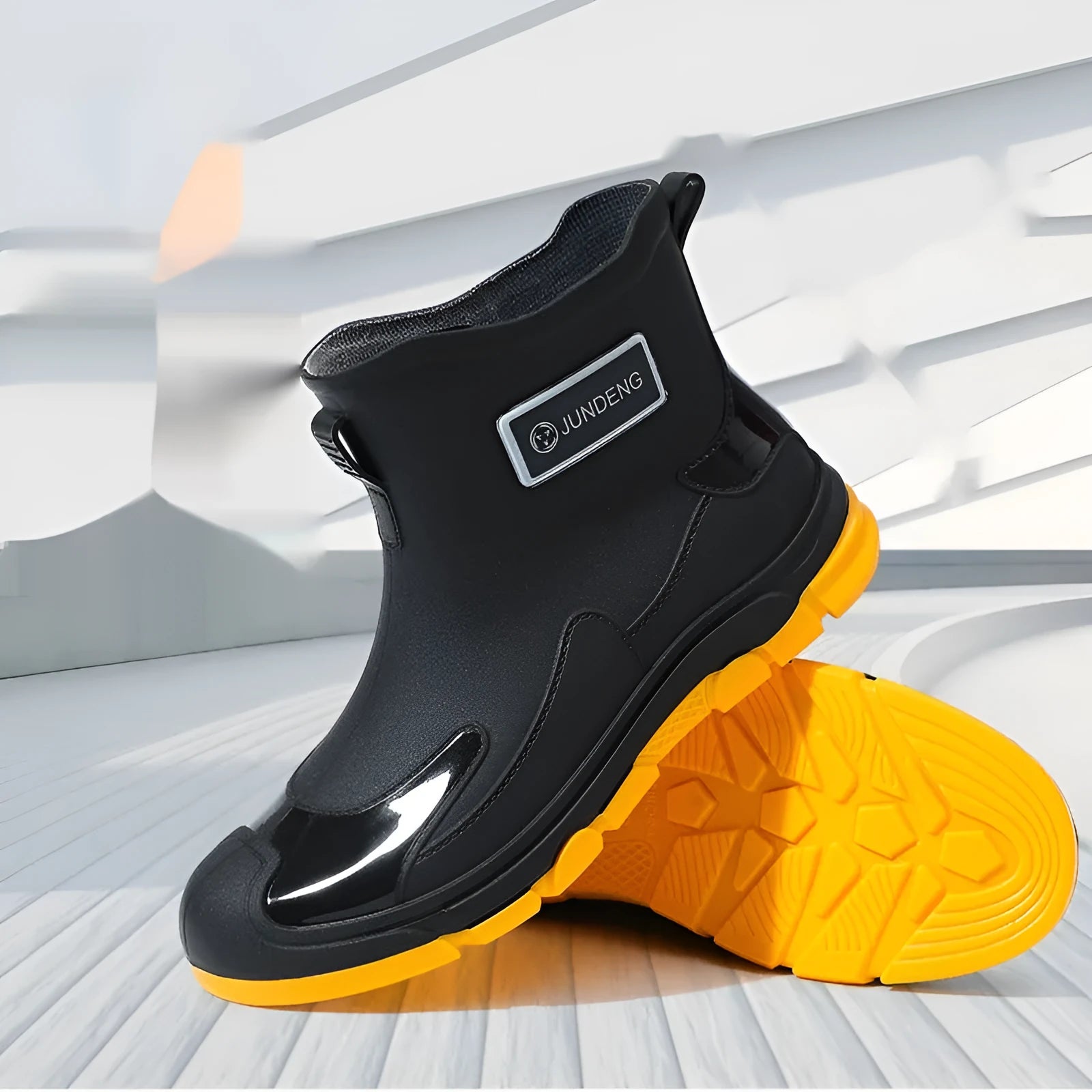 Minimalist black PVC waterproof wading boots with flat heel and round toe on a neutral background.