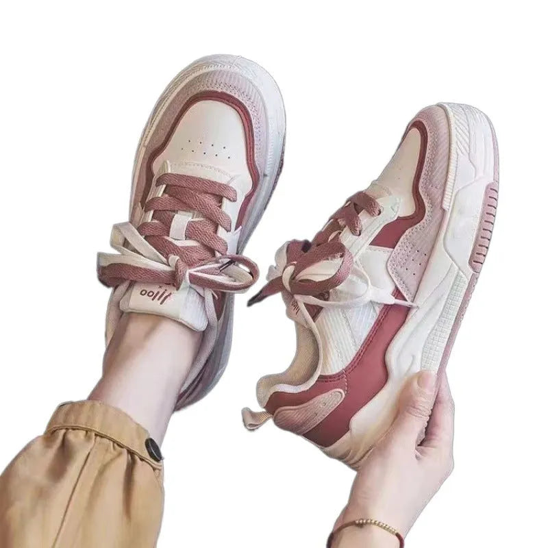 Pink and milky white low-top height-increasing sneakers with a rubber sole.