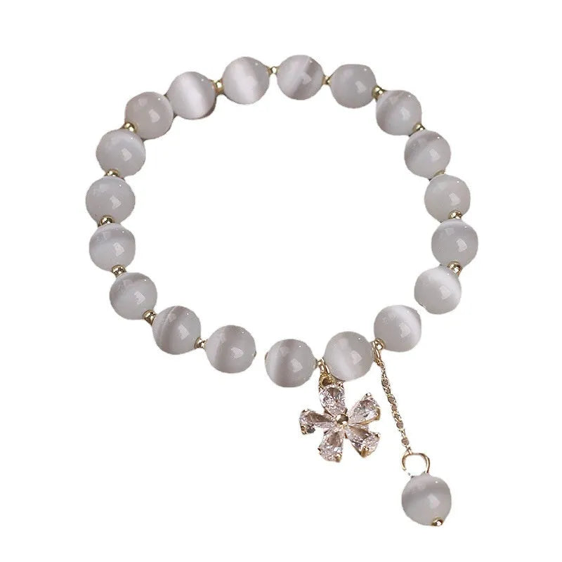 Women's white cat's eye crystal bracelet with flower tassels and a morganite safety buckle pendant.