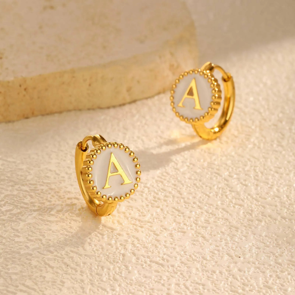 Round gold-tone letter earrings for women in stainless steel with electroplated finish, available in letters A to Z