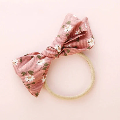 Children's cloth hair band with knotted bow design in one of six colour options