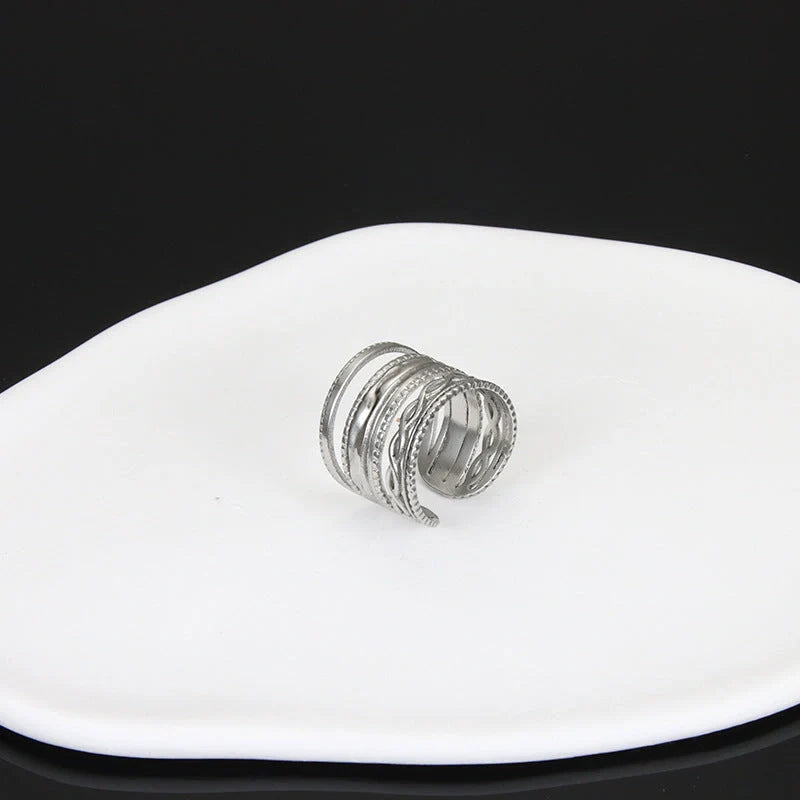 Adjustable stainless steel finger ring with unique charm designs in steel and gold finishes