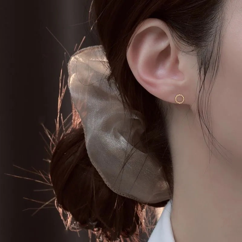 Pair of small spiral geometric ear studs with gold hollow thread finish in mixed material, shown in eight shape options.