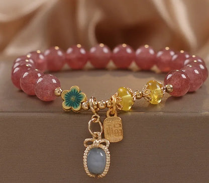 Red beaded bracelet with strawberry quartz gems, alloy clasp, and rhinestone details.