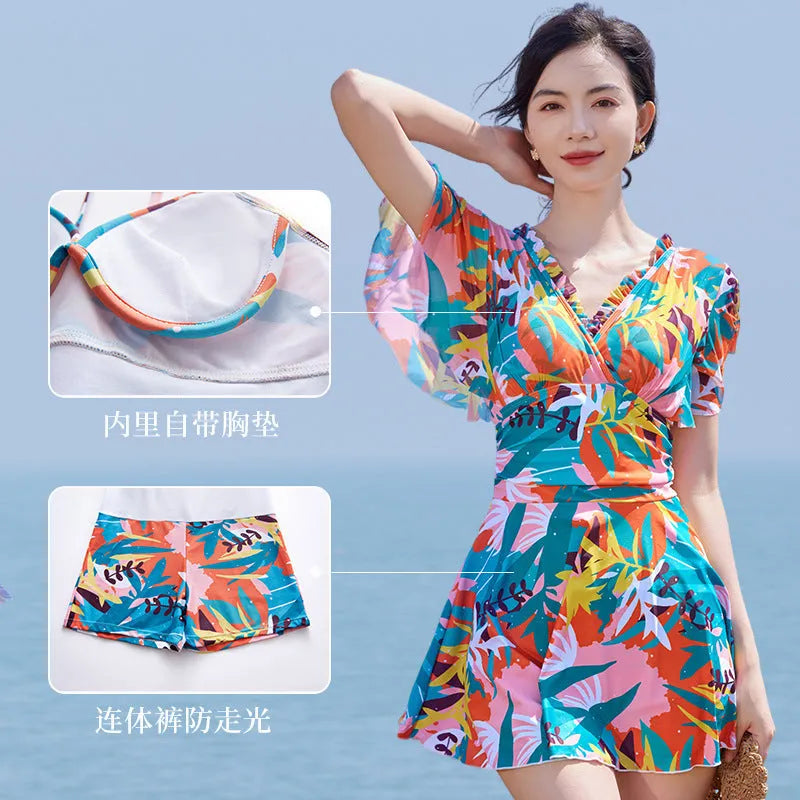 Women's colourful printed one-piece swimsuit on a mannequin, showing full coverage design.