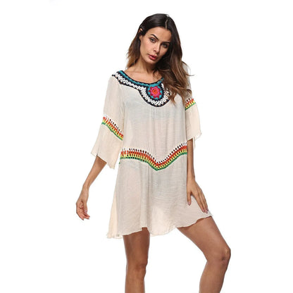 Crocheted white beach cover-up with open-knit design, worn over swimsuit, demonstrating UPF 50+ sun protection.