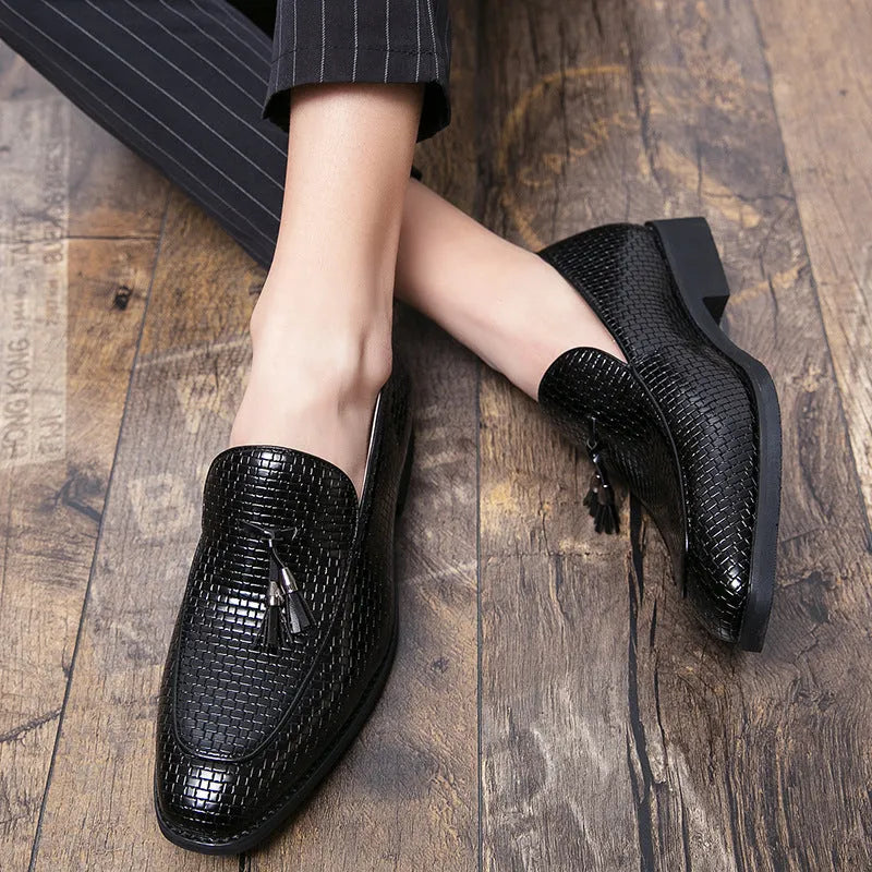 Men's black pointed toe slip on shoes with a tassel detail on the upper.