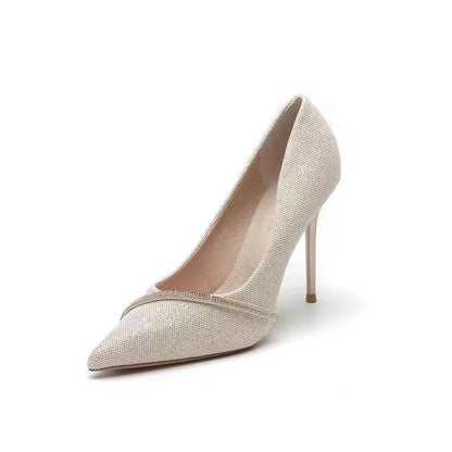 Gold women's stiletto high heels with pointed toe on a plain background.