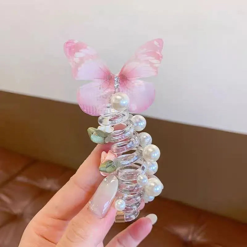 Colourful butterfly and pearl elastic hair band for children on a white background.