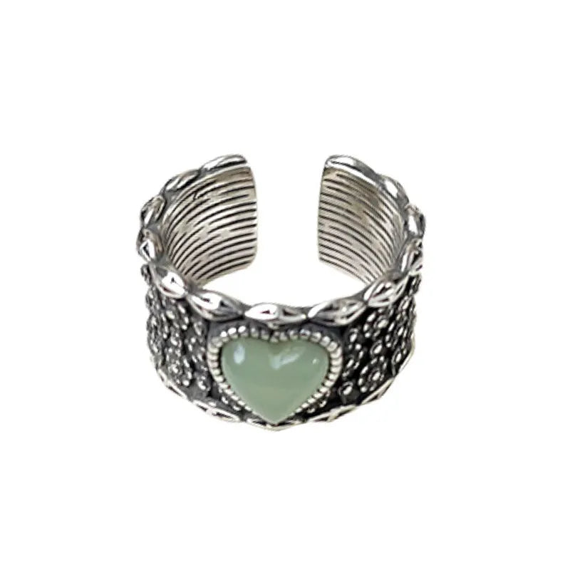 Retro style wide silver heart shape ring with adjustable band on a wooden surface