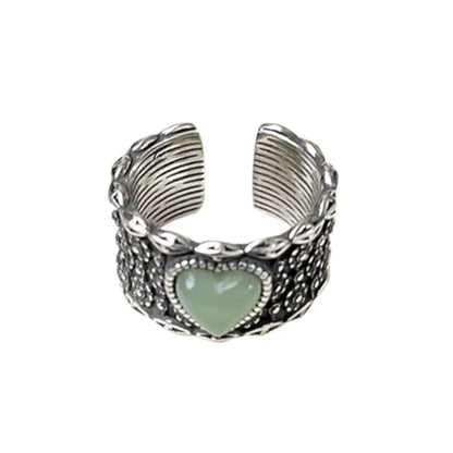 Retro style wide silver heart shape ring with adjustable band on a wooden surface