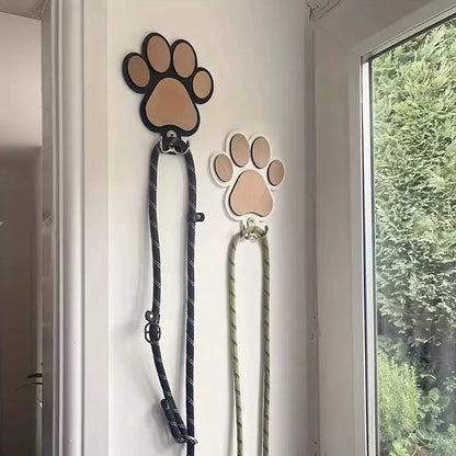 Black wooden wall hook shaped like a paw print foot on a white wall