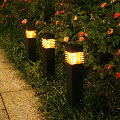 A tall, cuboid-shaped white solar lawn lamp standing in a garden.
