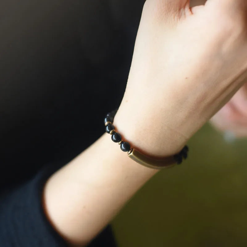 Layered stone and brass ethnic bracelet for men and women on a wrist.