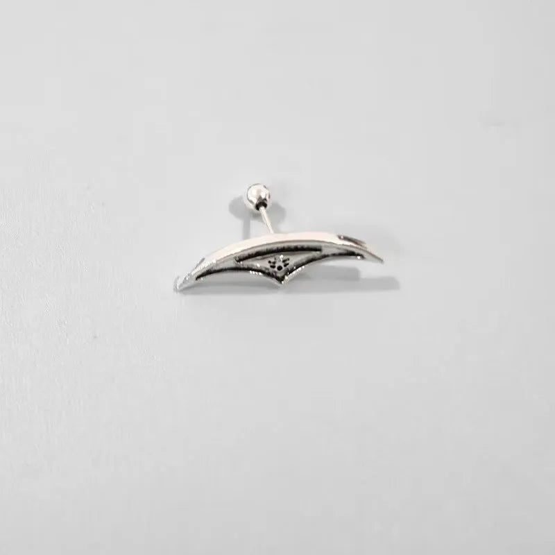 Close-up of a geometric spider web design on a gold-toned metal stud earring.