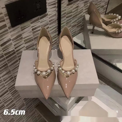 Women's black pointed toe patent leather stiletto high heels with pearl decoration on the upper.